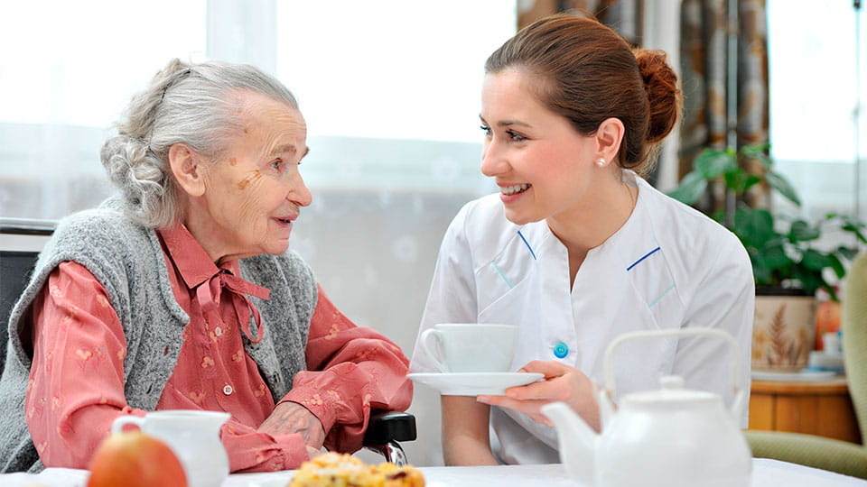 Demenz Seniorin und Pflegerin Essen und Kaffee