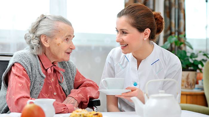 Demenz Seniorin und Pflegerin Essen und Kaffee