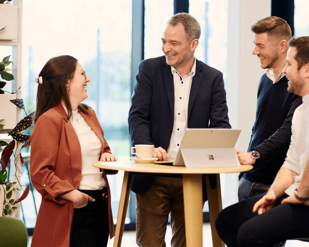 Mitarbeitende am Stehtisch in einem Meeting
