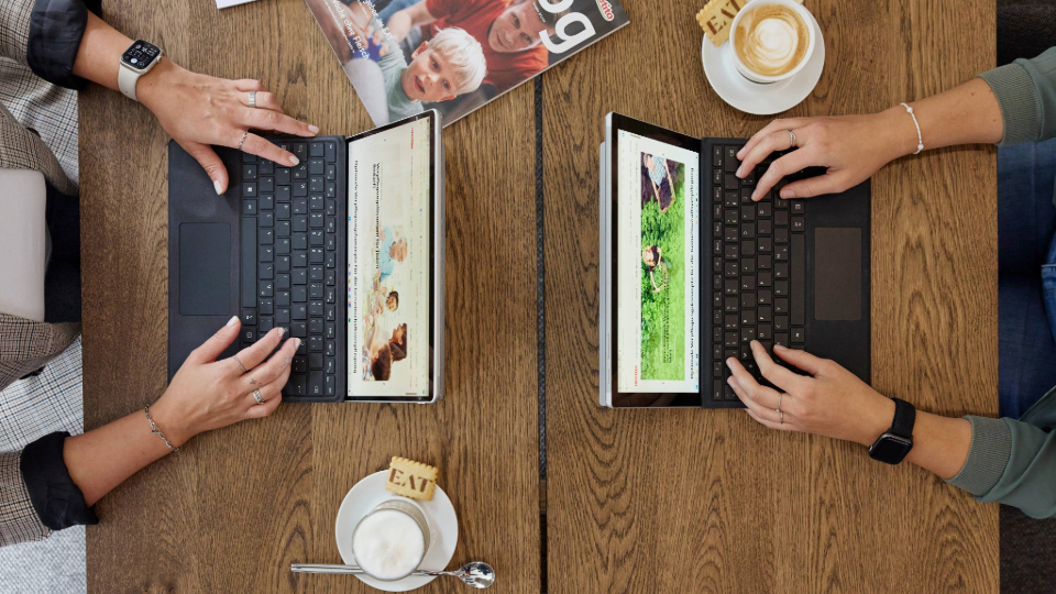 Zwei MitarbeiterInnen arbeiten an jeweils einem Laptop, auf diesem Bild sieht man jedoch lediglich die Hände der MitarbeiterInnen und deren Laptopbildschirm