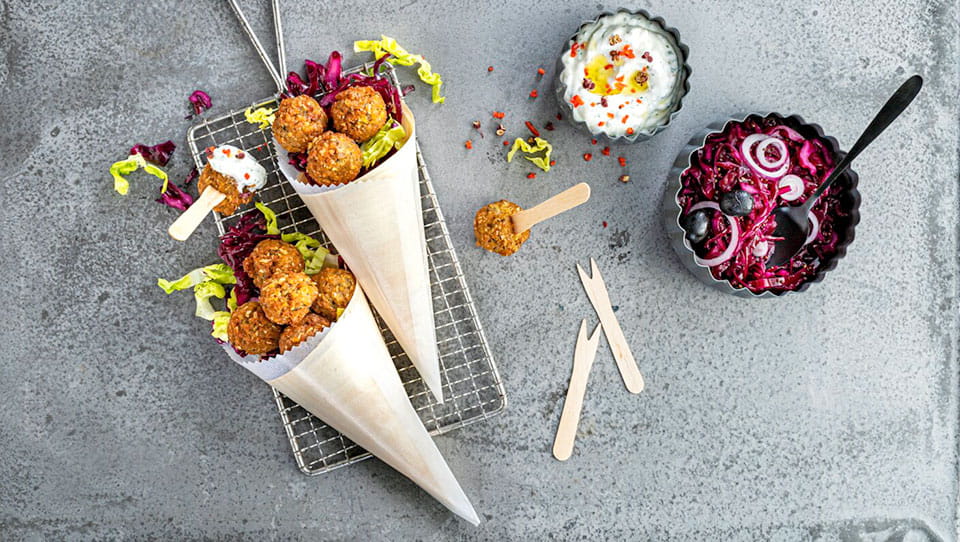 Falafelbaellchen-in-zwei-Papiertuetchen-mit-Dip-und-Rotkohl