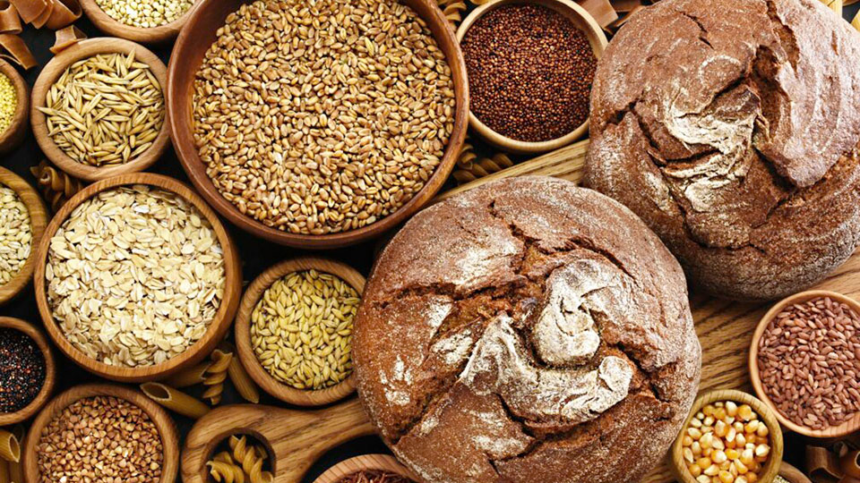 Brote-Getreide-und-Nudeln-auf-einem-Holztisch