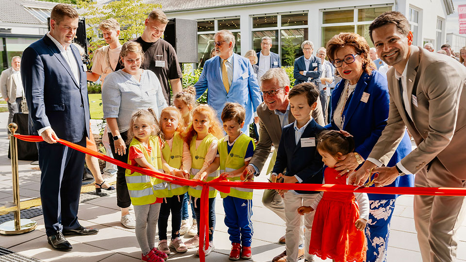 Band wird von mehreren Personen für die Eröffnung des EAT durchgeschnitten