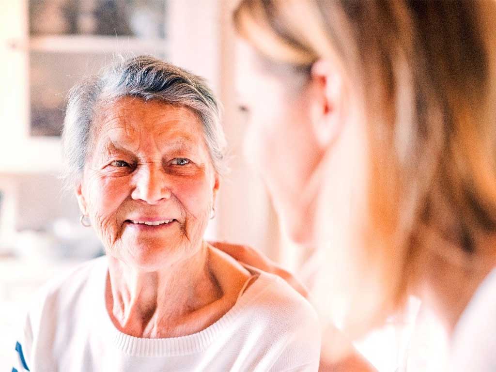 Ältere Frau lächelt jüngere Frau an