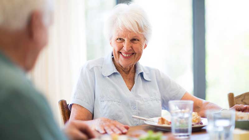 Seniorin-am-Esstisch-beim-Mittagessen