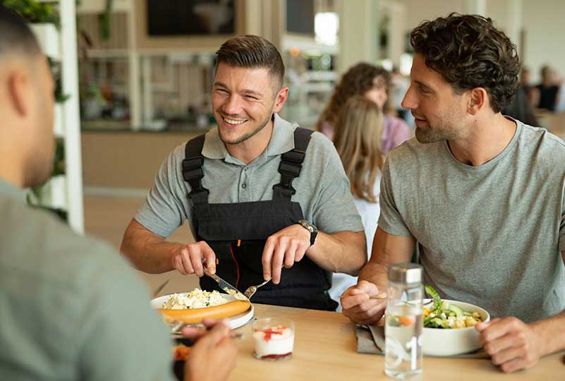 Drei-Mitarbeiter-beim-Mittagessen-im-Betriebsrestaurant