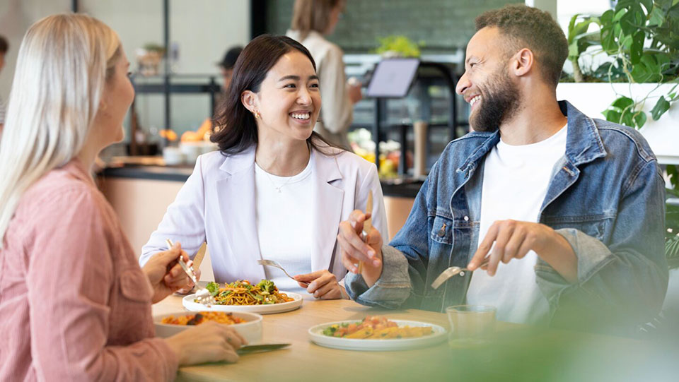 Mitarbeitende-bei-der-Mittagsverpflegung-im-Betriebsrestaurant-beim-Essen-am-Tisch