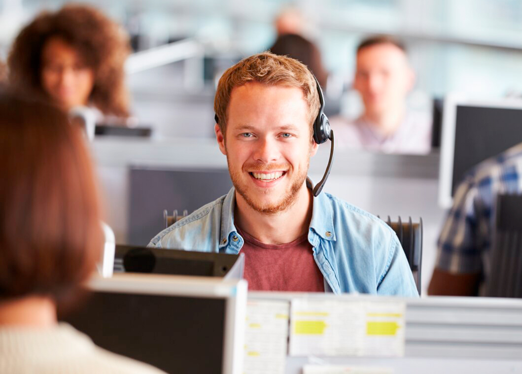 Mann-im-Buero-mit-einem-Headset-im-Telefonat