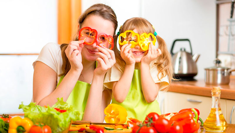 Mutter-und-Tochter-beim-gemeinsamen-Gemuese-schneiden