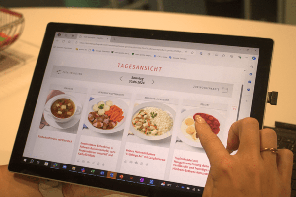 Person ist am Tablet im Menüshop
