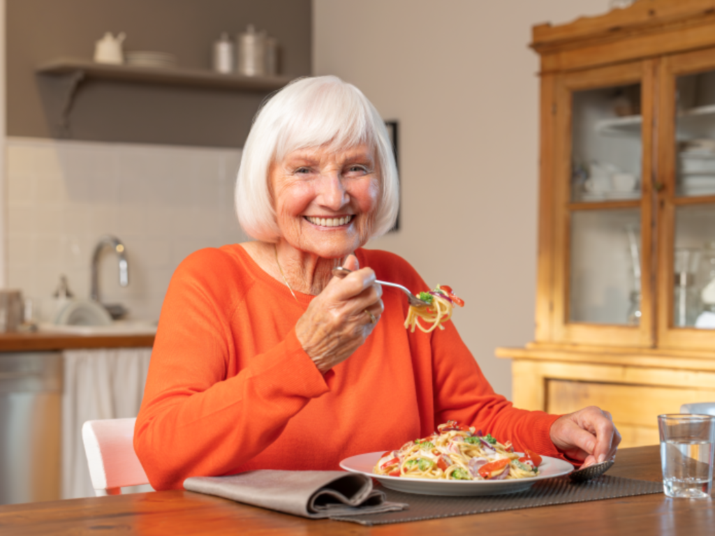 Ältere Dame am Essenstisch